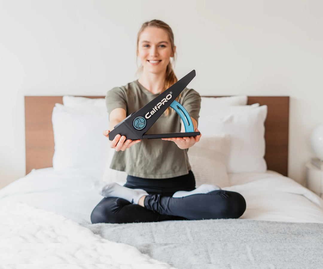 Person sitting on a bed holding a Calpro product best calf stretcher for plantar fasciitis 